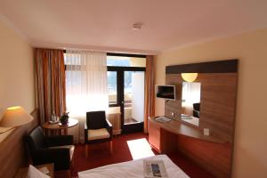 ein Hotelzimmer mit einem Bett und einem Schreibtisch in der Unterkunft Hotel Bergfrieden in Bad Wildbad