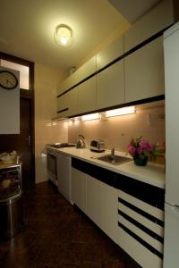 eine Küche mit weißen Schränken und einem Waschbecken in der Unterkunft Dalmatian Stone House in Baška Voda