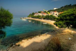 a beach with boats in the water and houses at Dalmatian Stone House in Baška Voda