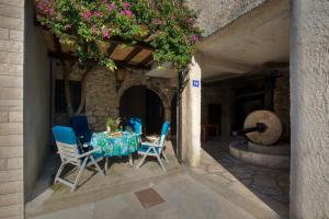 a table and chairs on a patio with flowers at Dalmatian Stone House in Baška Voda +4 photos