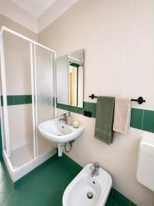 a green and white bathroom with a sink and a shower at Casa Moscati in Avellino +5 photos