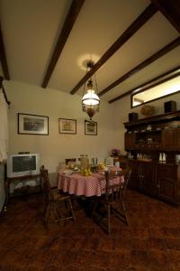 a dining room with a table and chairs and a television at Dalmatian Stone House in Baška Voda