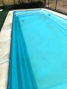 a swimming pool with blue water at Casas Rurales La Lapa in El Cerro del Hierro