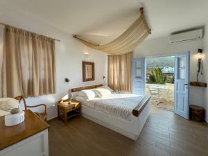a bedroom with a bed and a door to a patio at Chora Resort Hotel & Spa in Chora Folegandros +164 photos