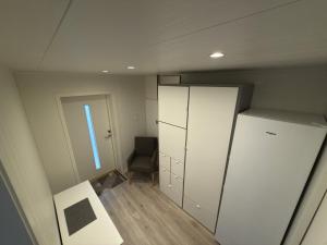 a small room with a refrigerator and a chair at Flakstadveien - Sentralt, midt i Lofoten in Napp