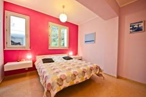 カンヌにあるRésidence Les Palmiers by Connexionのピンクの壁、ベッド1台付きのベッドルーム1室