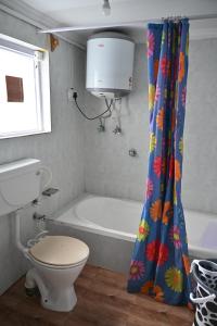 a bathroom with a tub and a toilet and a shower curtain at Himalayan Cottages Pahalgam in Pahalgām +21 photos