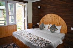a bedroom with a large bed with a wooden wall at Himalayan Cottages Pahalgam in Pahalgām