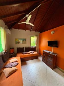 a bedroom with two beds and a ceiling fan at Gite d'Arles Bungalow "Orchidée" in Le Moule