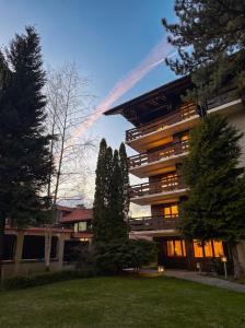 ein großes Gebäude mit Bäumen davor in der Unterkunft Hotel Pirin SKI & SPA in Bansko