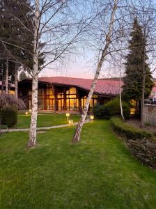 zwei Bäume im Gras vor einem Gebäude in der Unterkunft Hotel Pirin SKI & SPA in Bansko