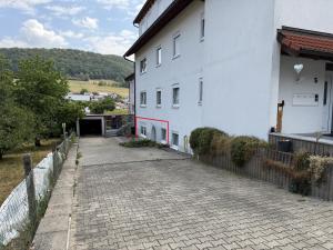 a white building with a brick road next to a fence at Müllers Bergnest in Deggingen