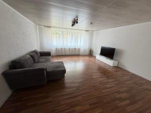 a living room with a couch and a flat screen tv at Müllers Bergnest in Deggingen