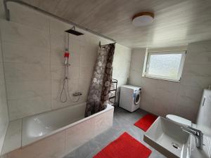 a bathroom with a tub and a sink at Müllers Bergnest in Deggingen