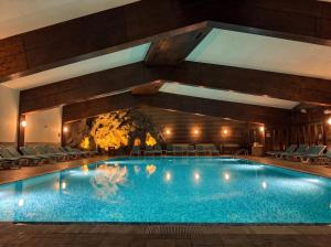 ein großes Schwimmbad in einem Hotel mit Stühlen in der Unterkunft Hotel Pirin SKI & SPA in Bansko
