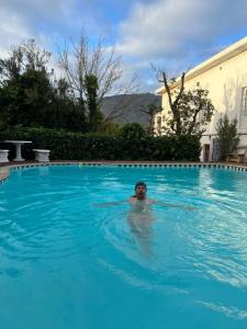 a man is swimming in a swimming pool at KAROO ART HOTEL 4 Star in Barrydale
