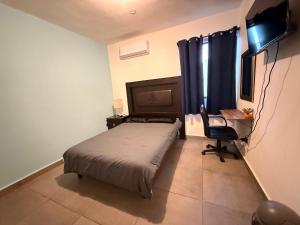 a bedroom with a bed and a desk and a chair at Casa súper Equipada Cumbres Dominio in Monterrey