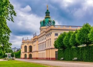 a yellow building with a green tower on top at Garner Hotel Berlin - Wilmersdorf by IHG in Berlin
