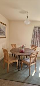 a dining room with a wooden table and chairs at Blackberry Cottage, Wood Farm in Shipdham