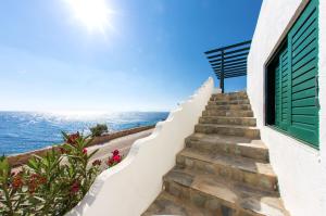 una escalera con una ventana y el océano en Pahivouni Studios & Suites en Donoussa