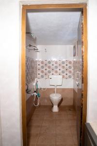a small bathroom with a toilet and a shower at My3 Dwarkamai in Vijayawāda +20 photos