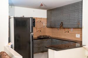 a kitchen with a stainless steel refrigerator and wooden walls at My3 Dwarkamai in Vijayawāda