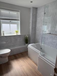a bathroom with a tub and a toilet and a sink at 25 Birch House in Oswestry