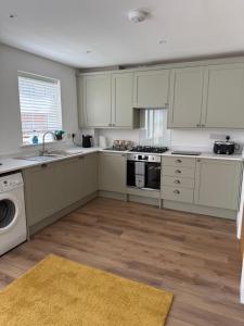 a kitchen with white cabinets and a stove top oven at 25 Birch House in Oswestry