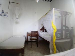 a room with two beds and two chairs in it at Lamu Sunsail Hotel in Lamu