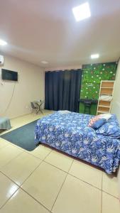 a bedroom with a bed and a video screen at Quarto próximo ao parque de exposição BR163 in Dourados