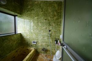 ein Badezimmer mit Badewanne, Toilette und Fenster in der Unterkunft Otowa音和 in Kijimadaira