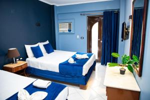 a hotel room with two beds and blue walls at Golden Sun Hotel - Hurghada in Hurghada +73 photos