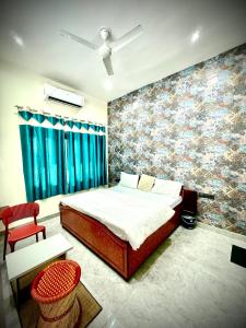 a bedroom with a bed and a wall with a mural at Hotel Ajanta in Pushkar