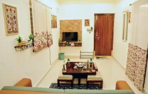 a living room with a table and a tv at 1 BHK by Agartha Atithya in Hyderabad