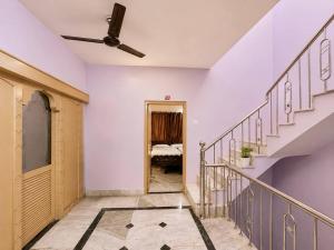 a hallway with stairs and a ceiling fan at Evergreen Bungalows in Dwarka