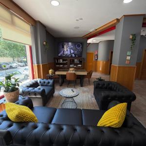 a living room with black couches and a tv at Residencia Porta Nova in Ferrol