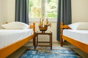 a bedroom with two beds and a table between them at Apartments Danilo in Herceg-Novi
