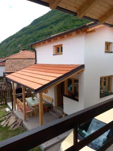 a white house with a red roof and a table at Smestaj kod Sneze in Dojkinci