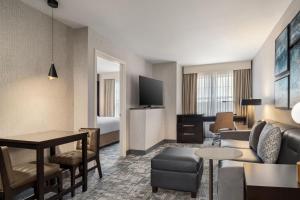 a hotel room with a couch and a table at Courtyard by Marriott Long Island Islip/Courthouse Complex in Central Islip
