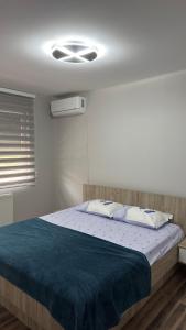a bedroom with a bed with a blue blanket at Vila Manuela in Gevgelija