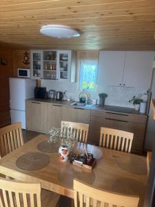 a kitchen with a wooden table with chairs and a dining room at Domek na wzgórzu in Tabaszowa