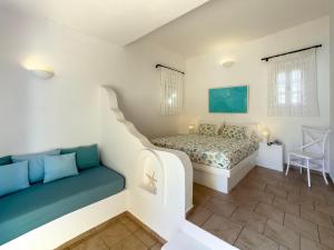 a bedroom with a bed and a couch at Chora Resort Hotel & Spa in Chora Folegandros