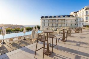 a row of tables and chairs on the roof of a building at Gran Hotel Suances Suites in Suances