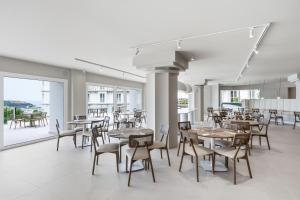 a dining room with tables and chairs and windows at Gran Hotel Suances Suites in Suances