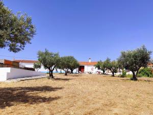 a field with trees in front of a building at Refúgio do Artur - Casa no Campo in São Marcos do Campo