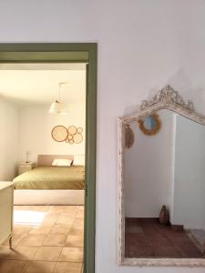 a bedroom with a bed and a mirror at Refúgio do Artur - Casa no Campo in São Marcos do Campo