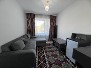 a living room with a couch and a television at Ala-Too Hotel in Naryn