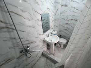a white bathroom with a sink and a mirror at Ala-Too Hotel in Naryn