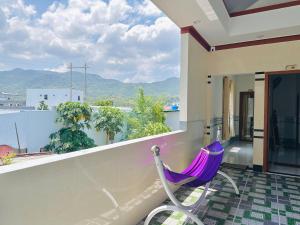 a purple hammock on the balcony of a house at SUN Homestay Vĩnh Hy in Vĩnh Hy