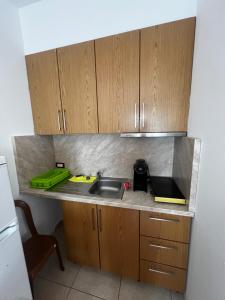 a kitchen with wooden cabinets and a sink at Eli Apartments in Tale